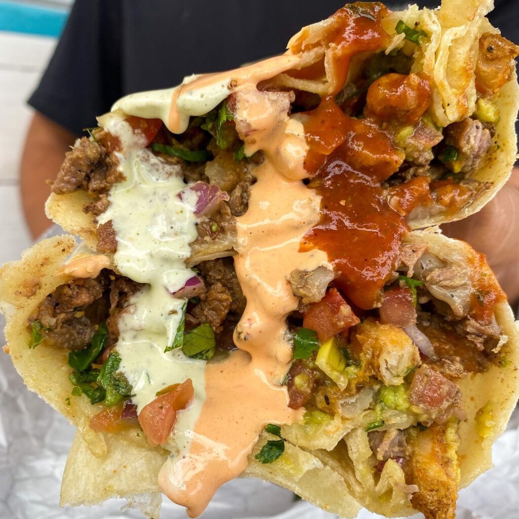 a close up view of two loaded tacos