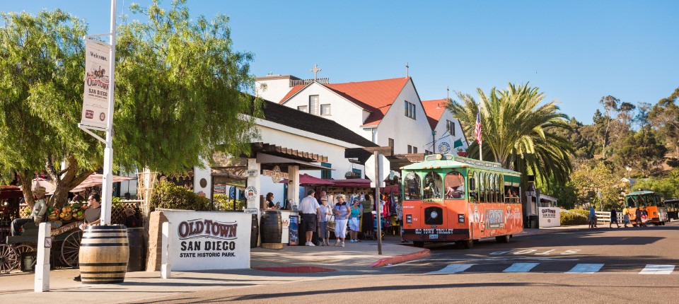 a busy city street corner  with a sign that reads "Old Town San Diego"